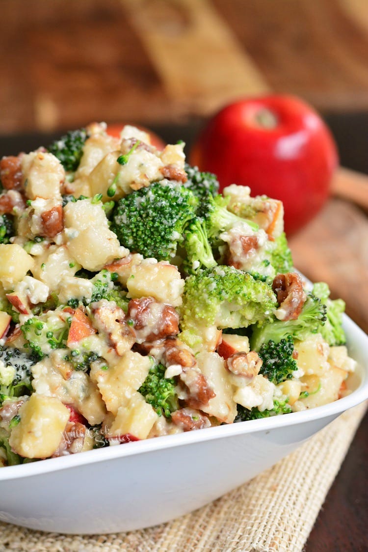 Pear Apple Broccoli Salad in a bowl on a table with a apple in the background 