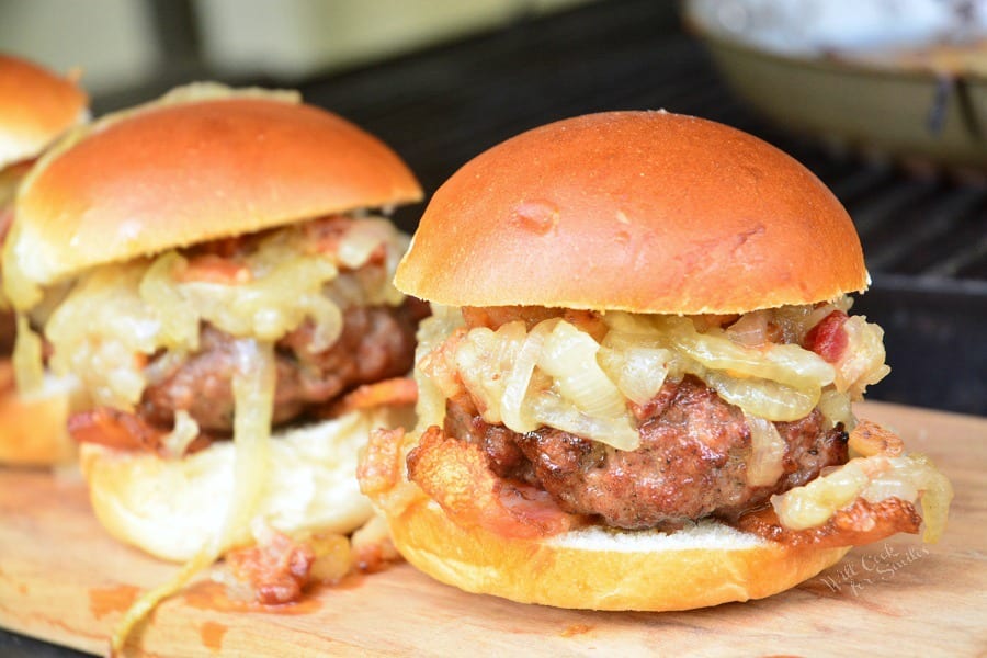 Bacon Burger Sliders with Bacon Caramelized Onions in a bun on a cutting board