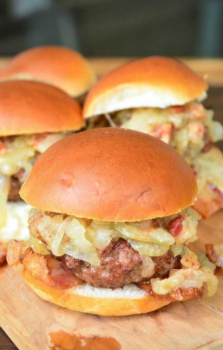 Bacon Burger Sliders with Bacon Caramelized Onions on a bun sitting on a cutting board 