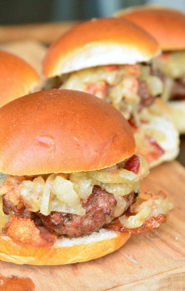 Bacon Burger Sliders with Bacon Caramelized Onions in a bun on a cutting board