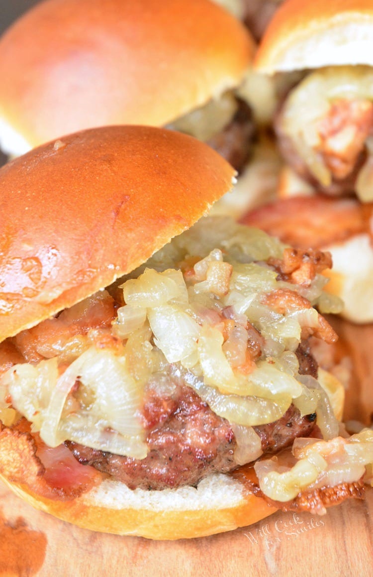 Bacon Burger Sliders with Bacon Caramelized Onions in a bun on a cutting board