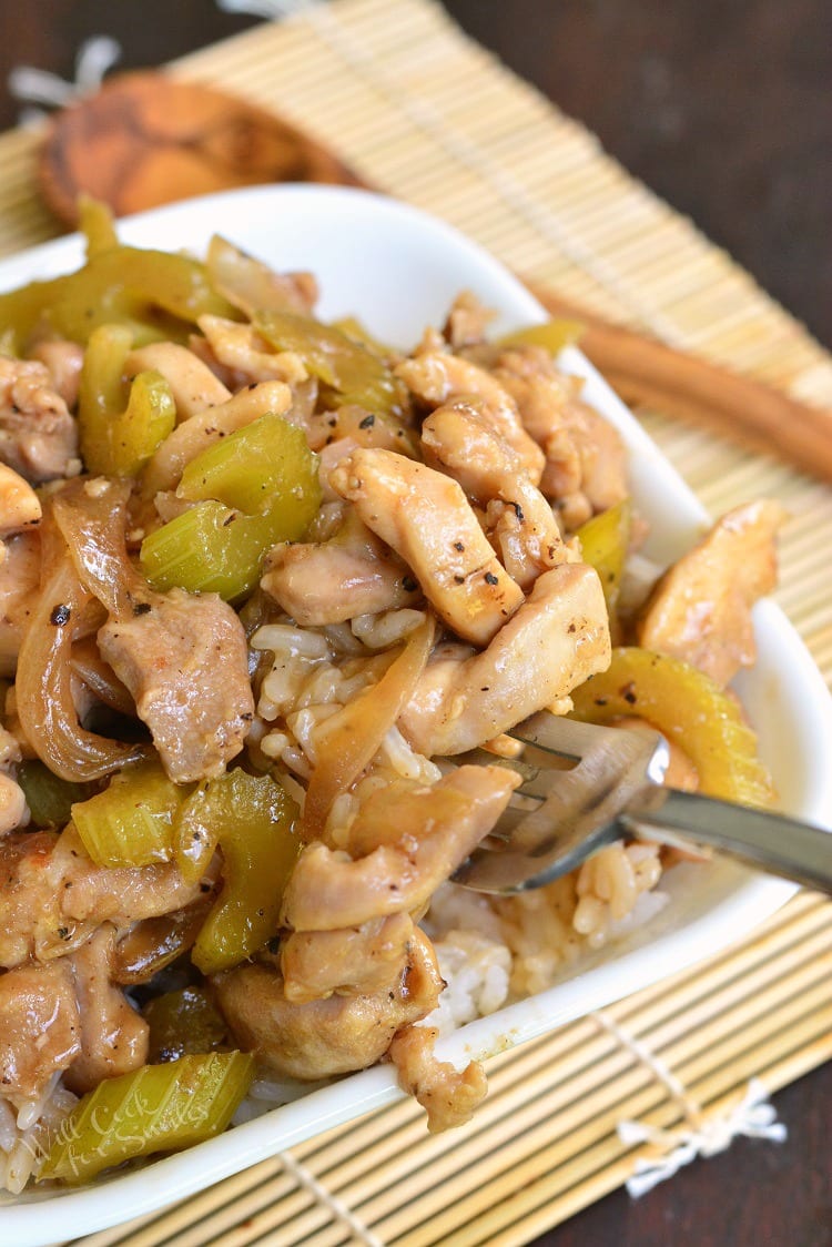 scooping chicken with a fork out of the bowl