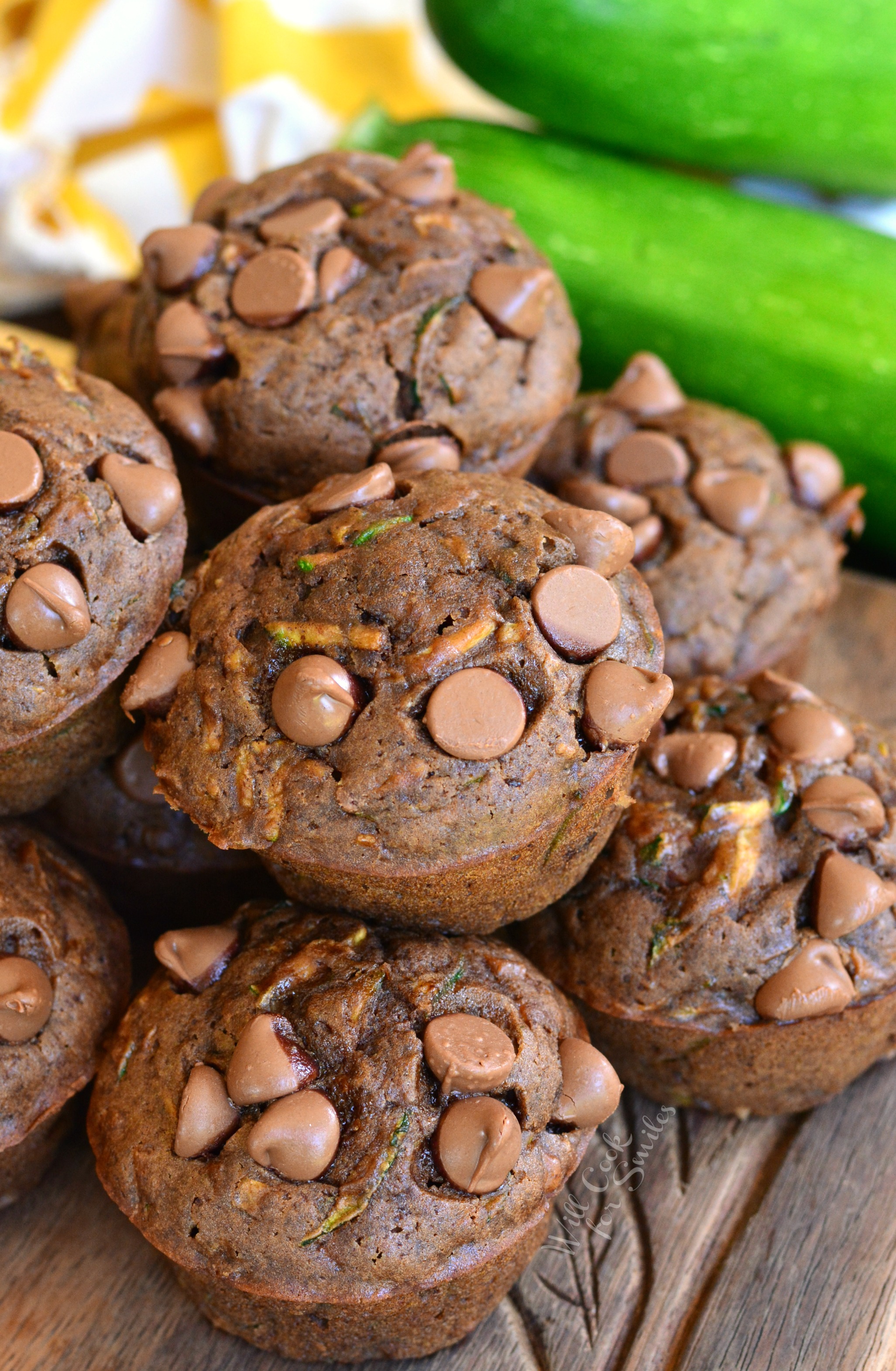 Chocolate Zucchini Muffins stacked on a wood cutting board 
