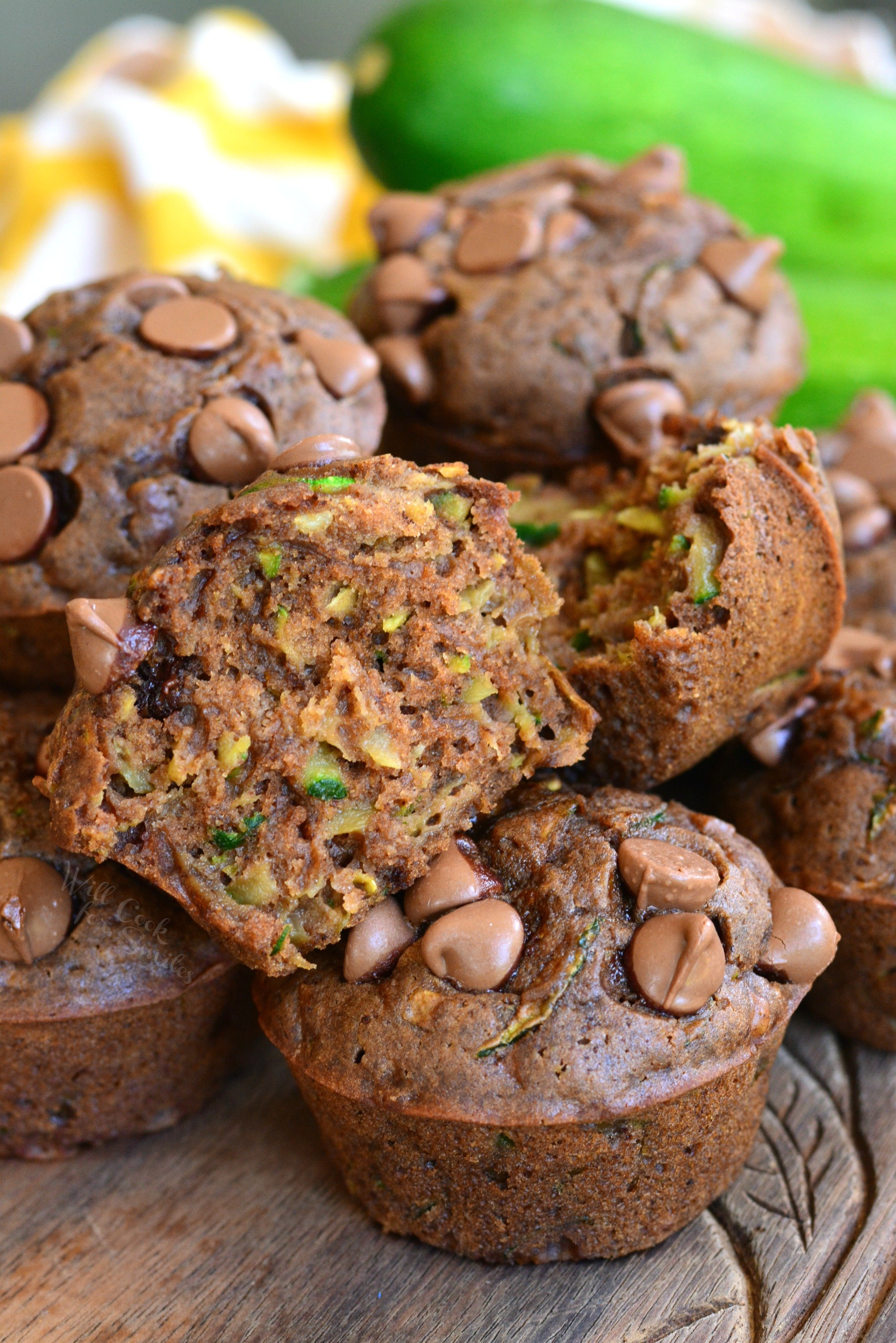 Chocolate Zucchini Muffins on a cutting board with one cut in half 