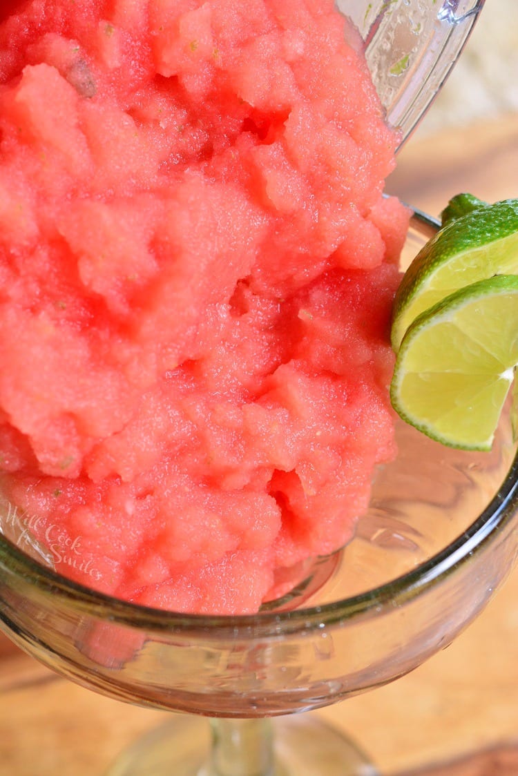 pouring the frozen margarita into a glass.