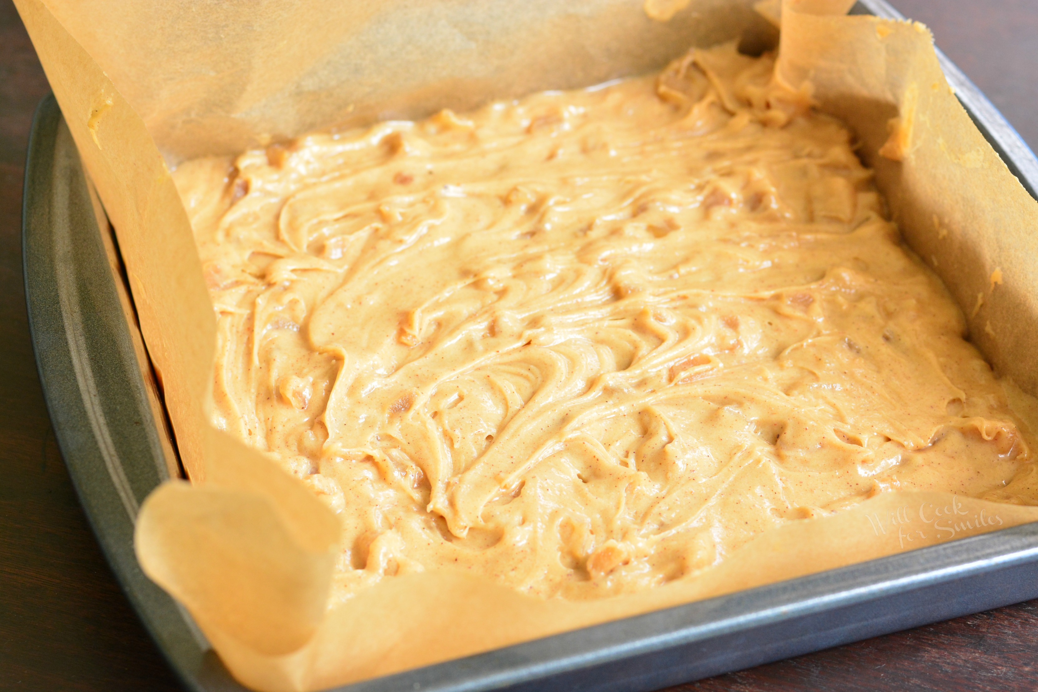 Apple Pie Blondies in parchment paper in a baking pan 