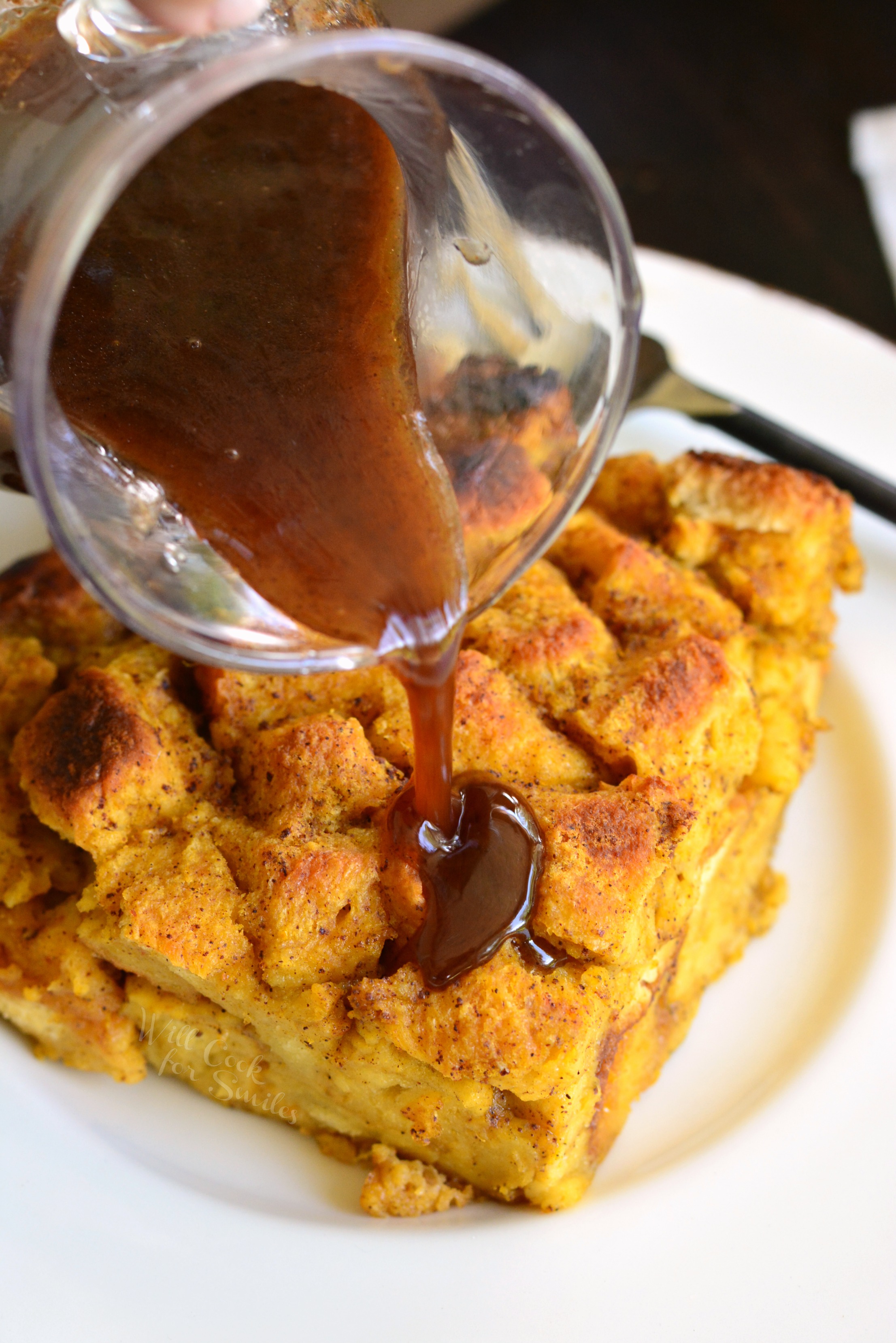 Brioche Pumpkin Bread Pudding with syrup being poured over 