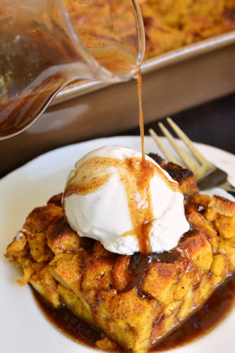 pouring rum sauce over the ice cream on top of the pumpkin bread pudding slice.