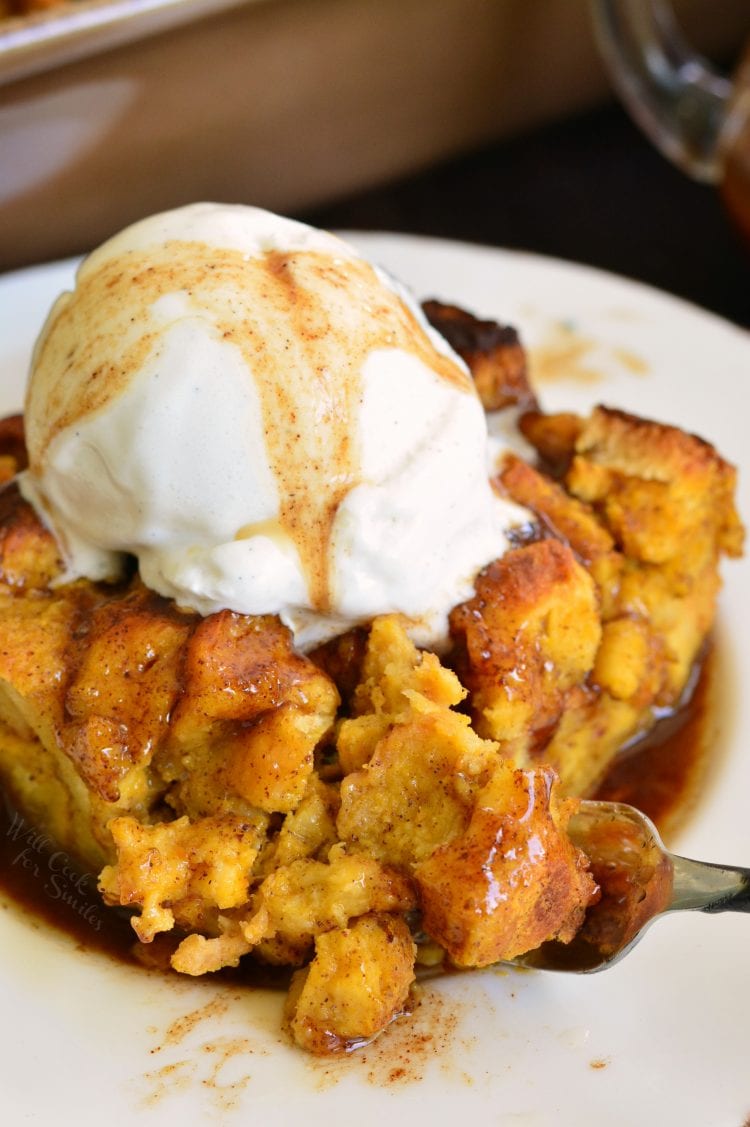 cutting off a slice of pumpkin brioche topped with ice cream with a fork.