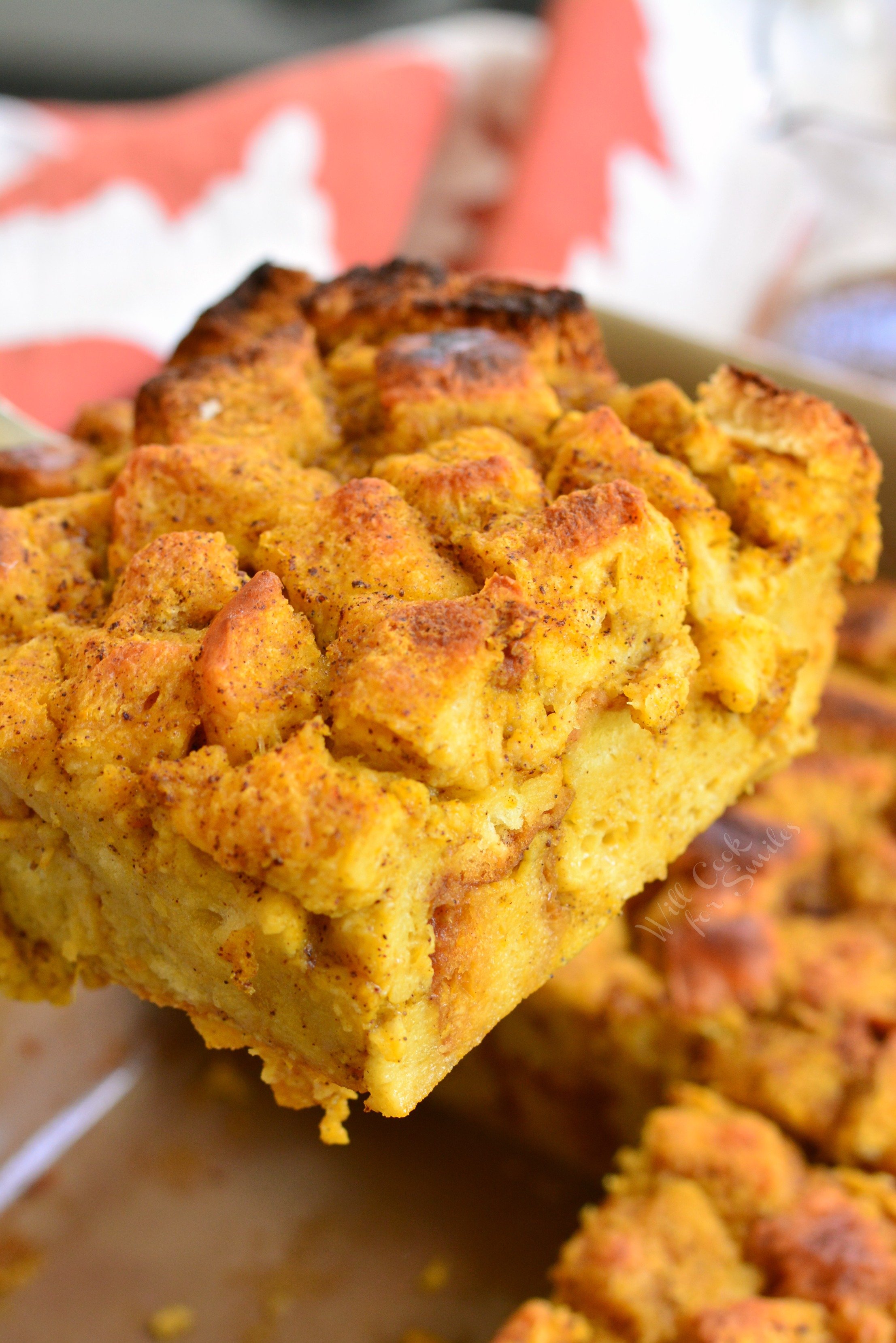 Brioche Pumpkin Bread Pudding being lifted out of pan with spatula 