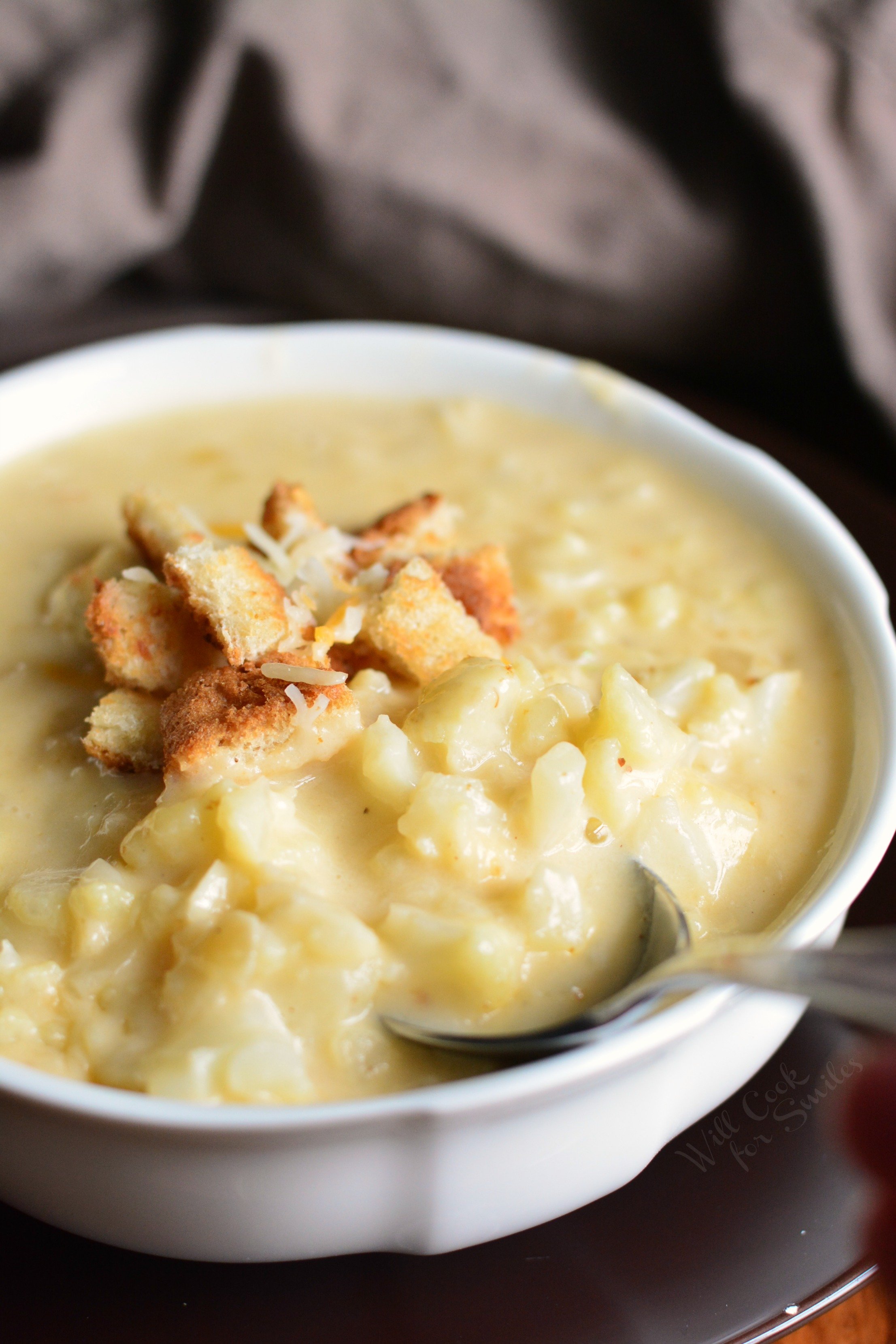 Cauliflower Cheese Soup in a bowl with a spoon 