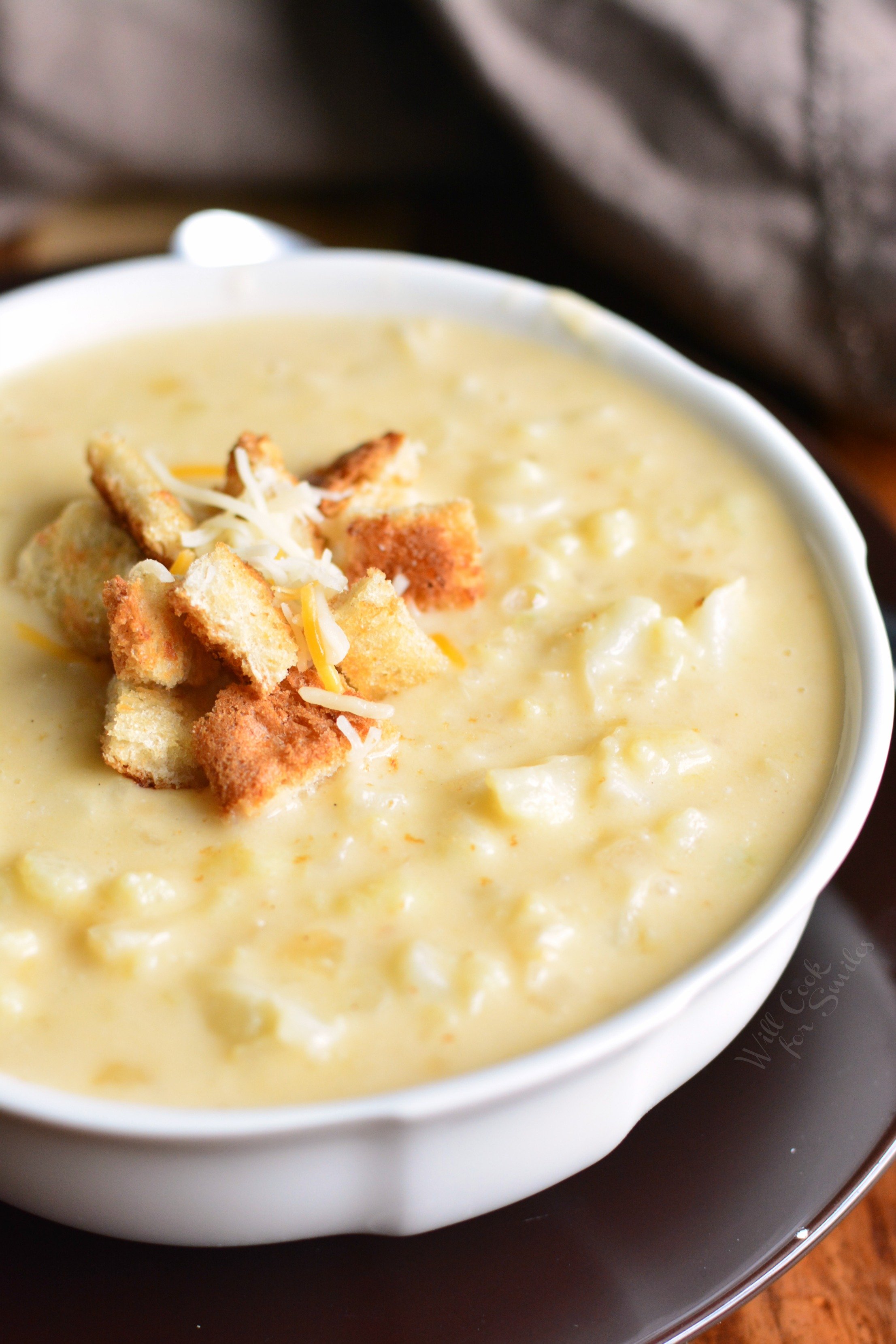 Cauliflower Cheese Soup in a bowl with croutons and cheese on top 
