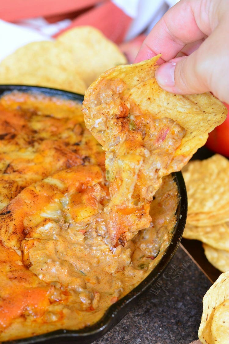 Creamy Beef Taco Dip with chip being dipped in 
