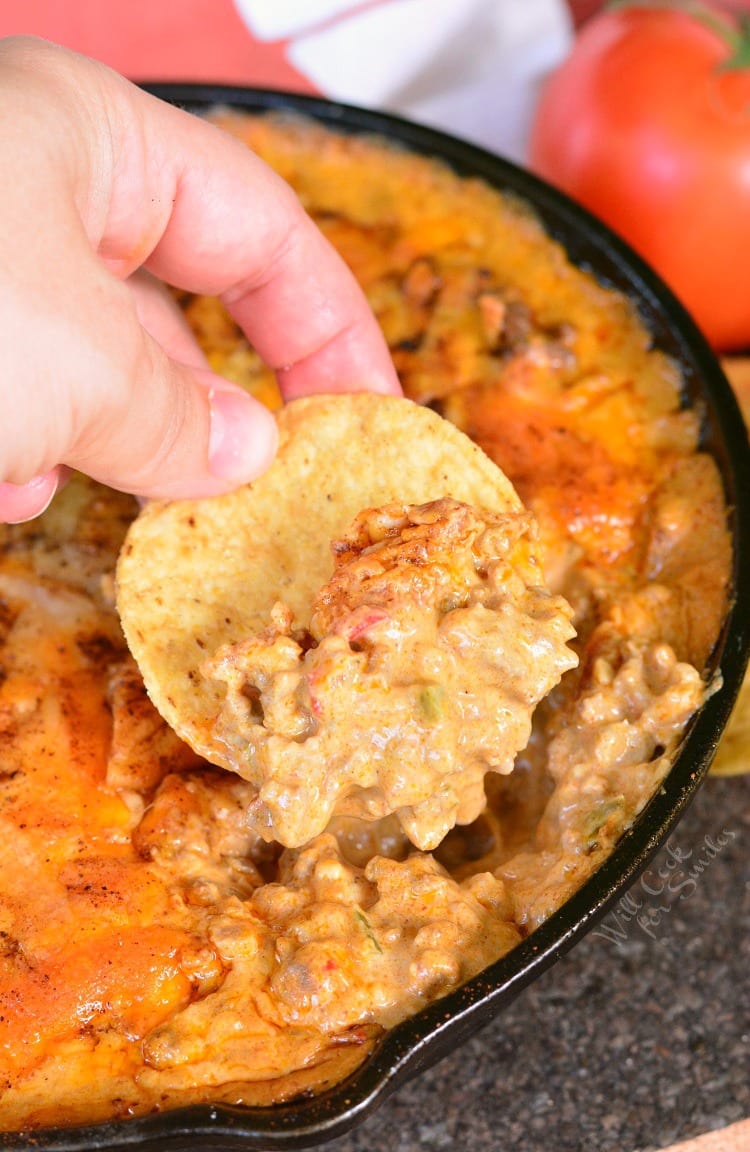 Creamy Beef Taco Dip with chip being dipped in 