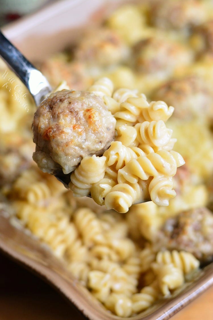 scooping some Swedish Meatballs Pasta Casserole out of casserole dish with a fork 