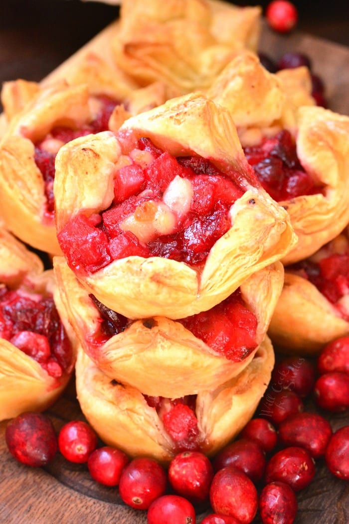 Apple Cranberry Brie Puff Pastry stacked on a cutting board with cranberries 