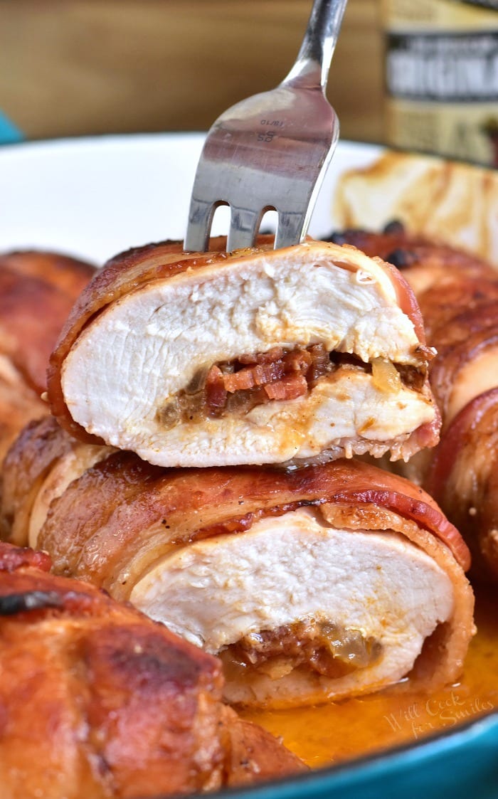 Bacon Wrapped BBQ Stuffed Chicken Breasts cut in half with a fork in it 