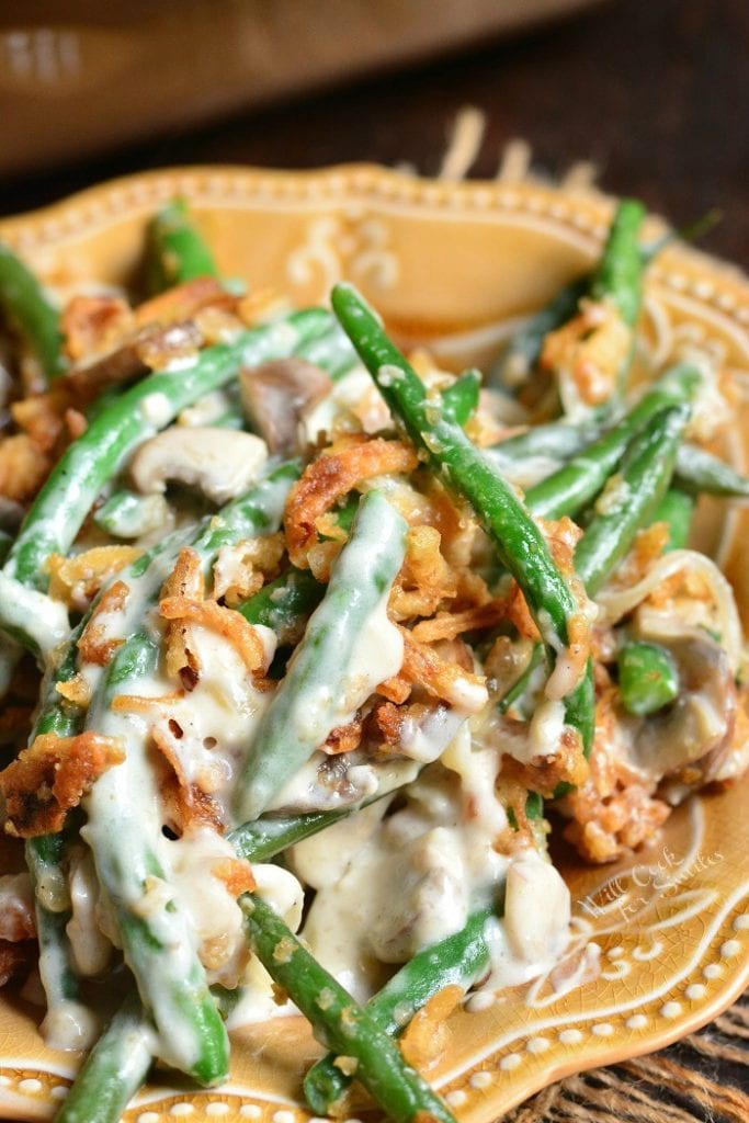 portion of green bean casserole on a light brown dish.