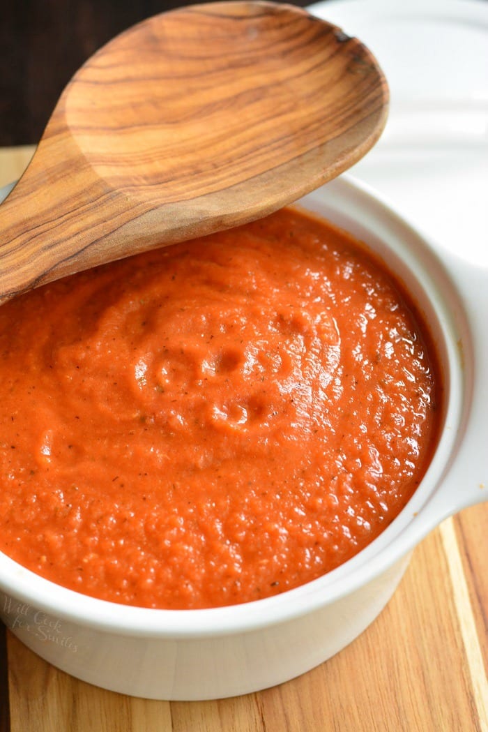 pasta sauce in a bowl with a wooden spoon on a wood table 