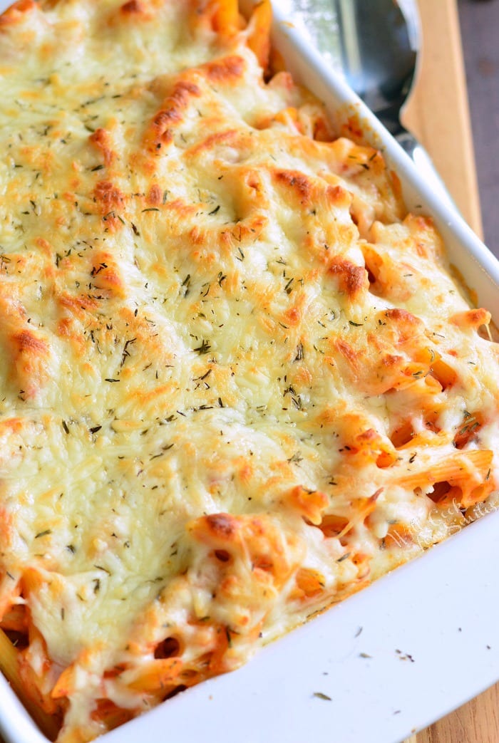 Homemade Basil Roasted Garlic Baked Penne in a baking dish on a wood table 