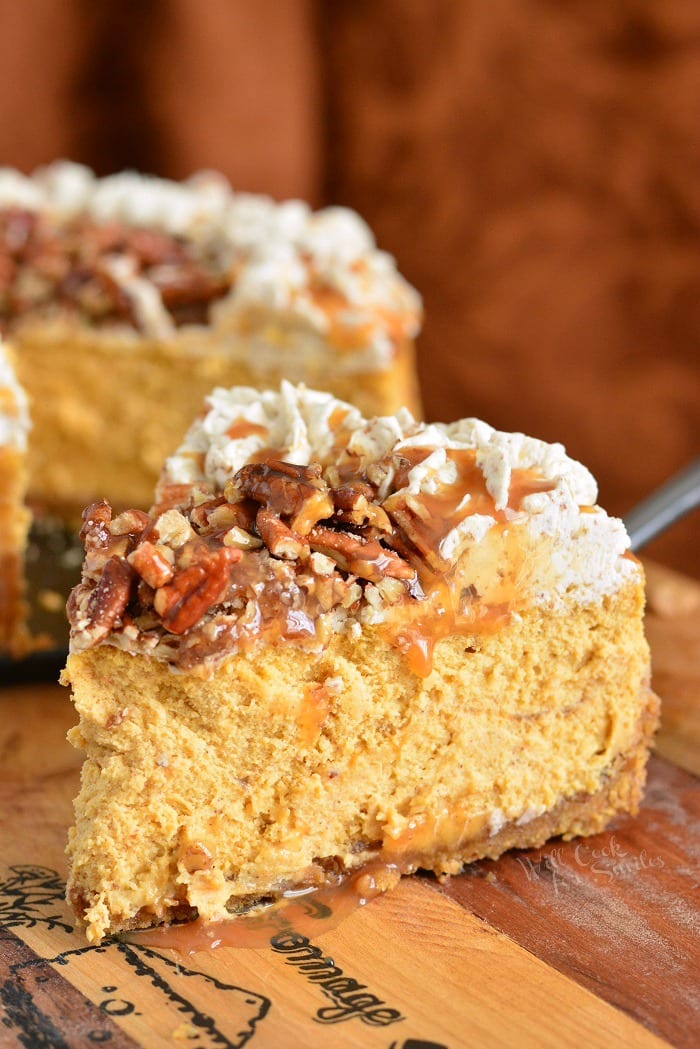 Pecan Caramel Pumpkin Cheesecake slice on a cutting board 