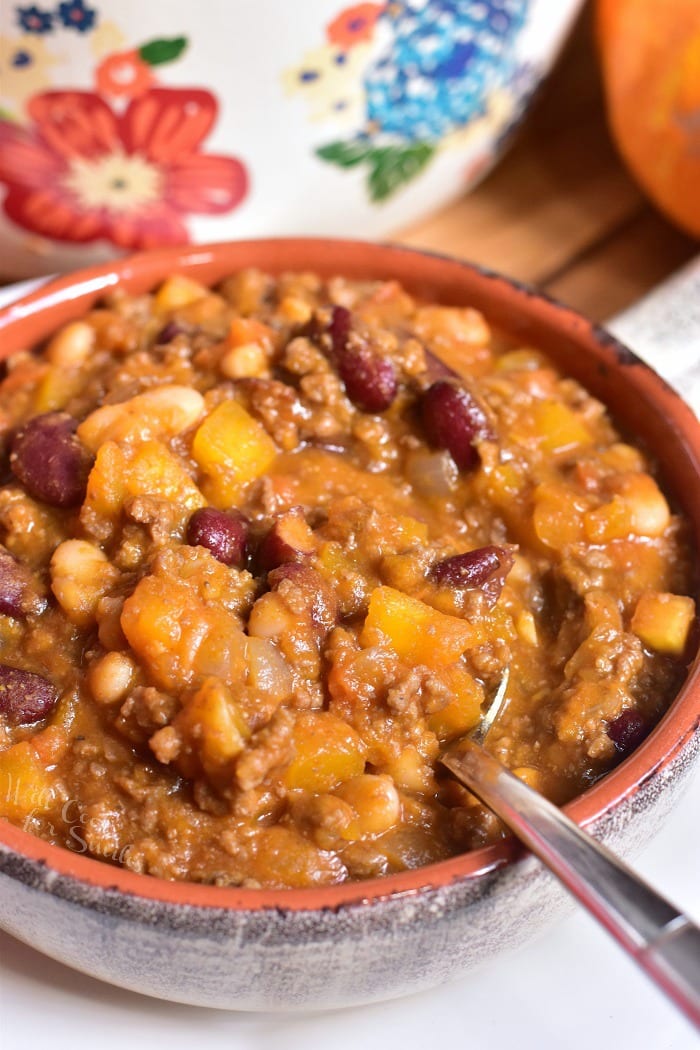 Pumpkin Chili in a bowl with spoon on a table 