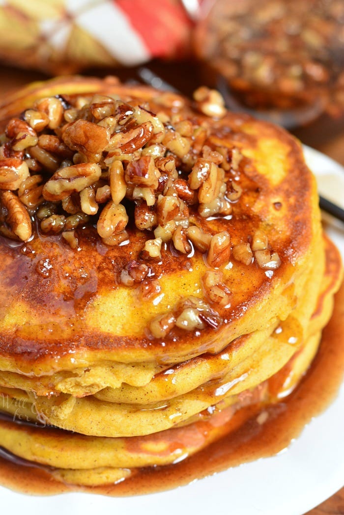 Pumpkin Pancakes with Cinnamon Pecan Syrup stacked on a plate 