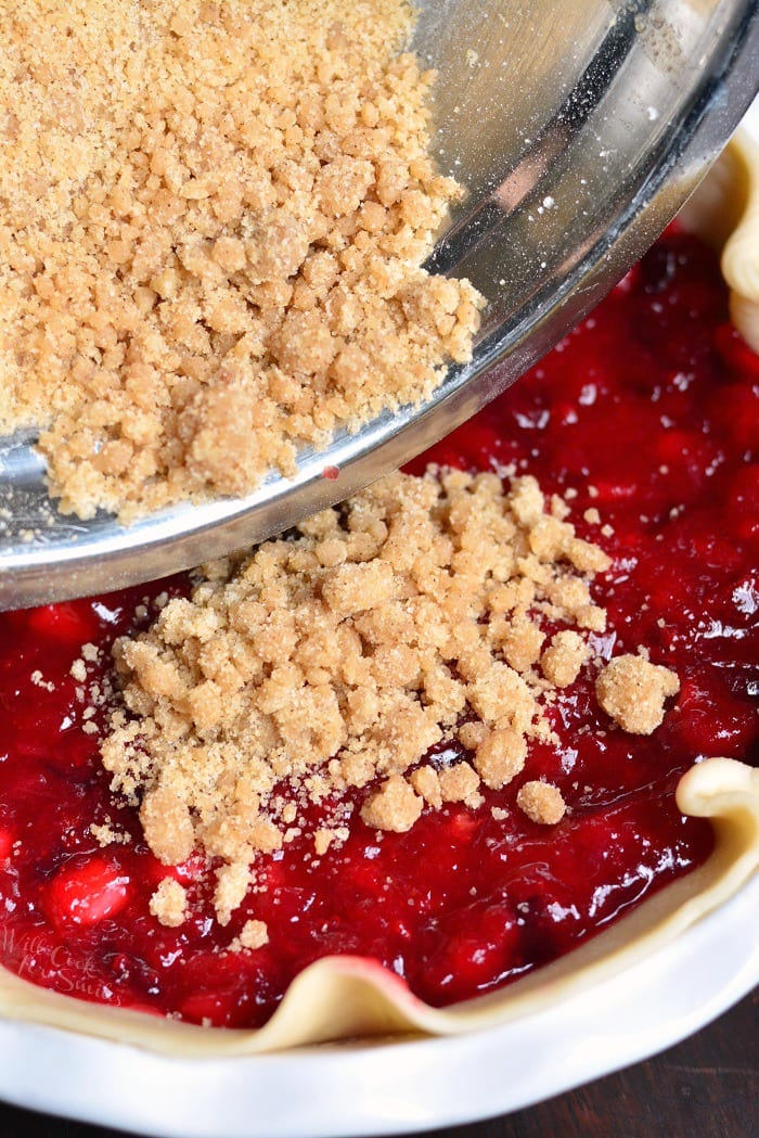 pouring on Apple Cranberry Pie topping 