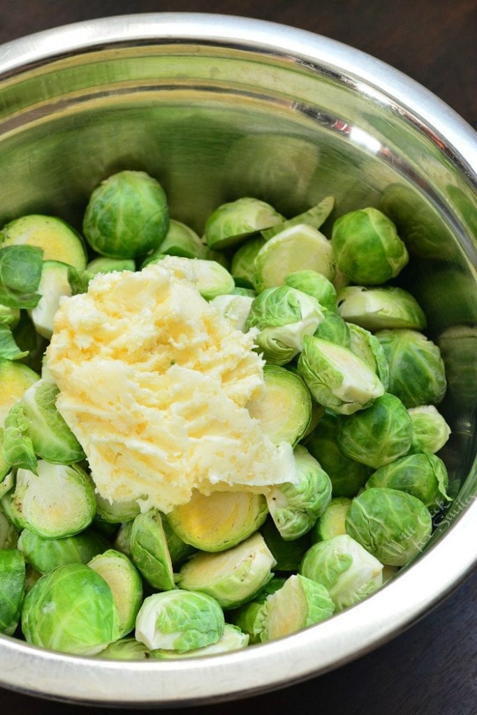 brussels sprouts cut in half in a bowl with butter. 