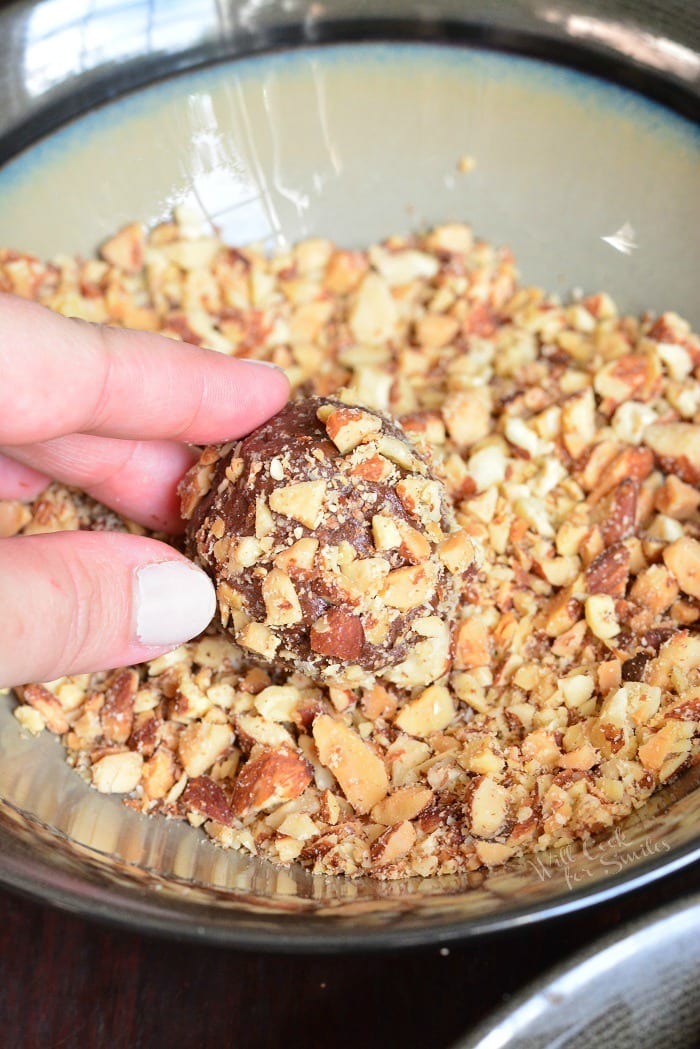 uncooked Nutella Cookies being rolled in nuts 