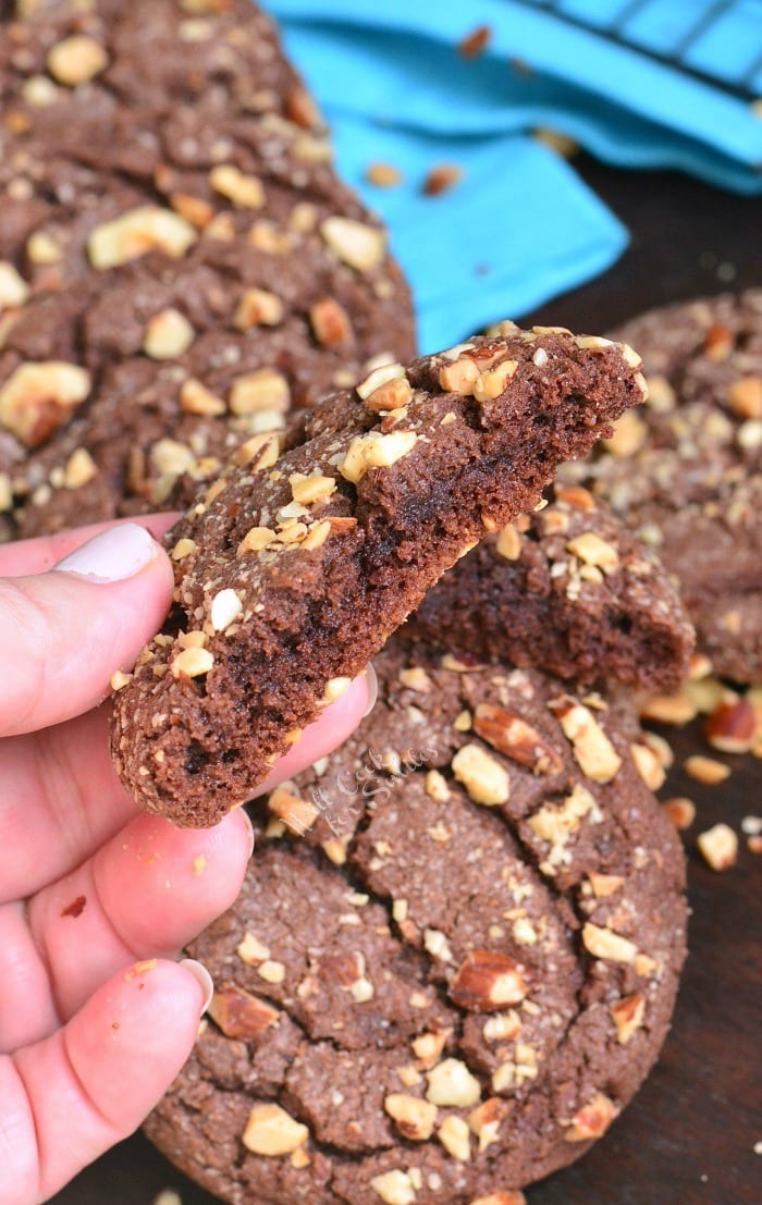 holding half of a soft and chewy Nutella cookie to see the center.