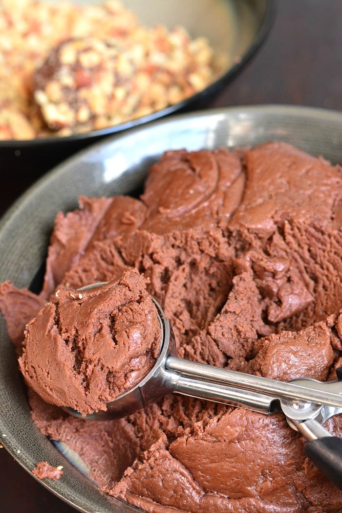 scooping Nutella Cookies out of metal bowl with a scoop