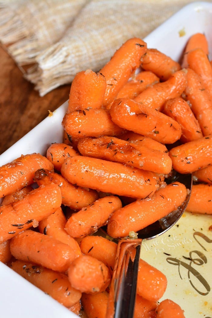 Balsamic Roasted Carrots in a baking dish with a serving spoon 