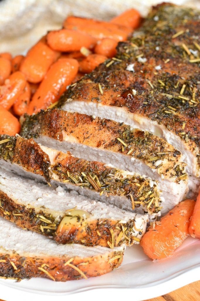 closeup sliced pork loin with side of carrots.