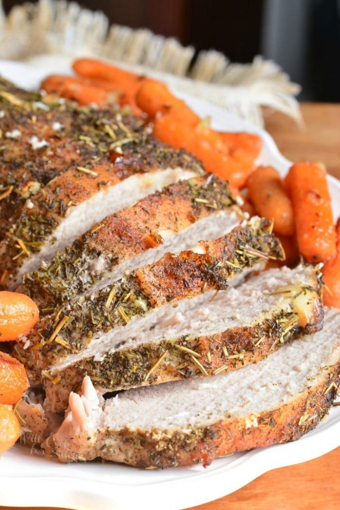 sliced pork loin on the white plate with carrots.