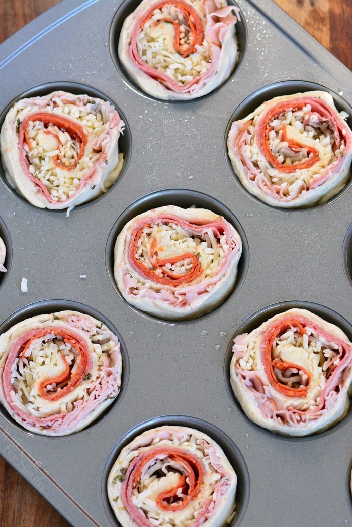 Italian Sub Pinwheels uncooked in a muffin pan to cook 