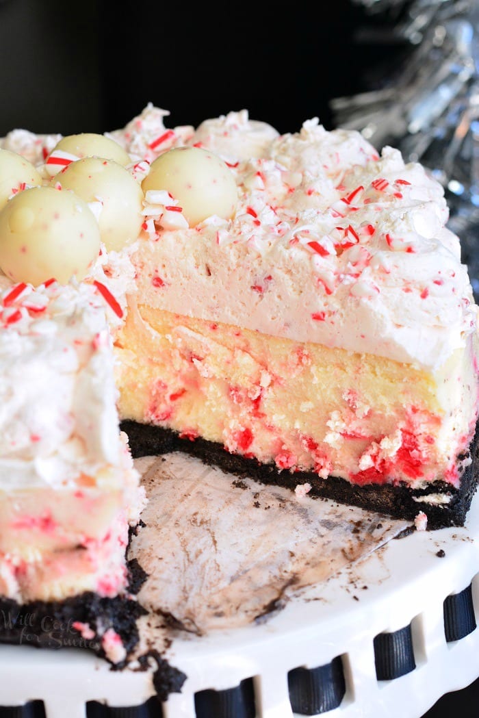 Peppermint Cheesecake on a cake stand with a slice missing 