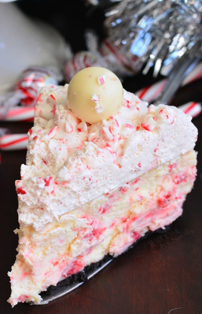 Peppermint Cheesecake slice on a table with candy canes in the background 