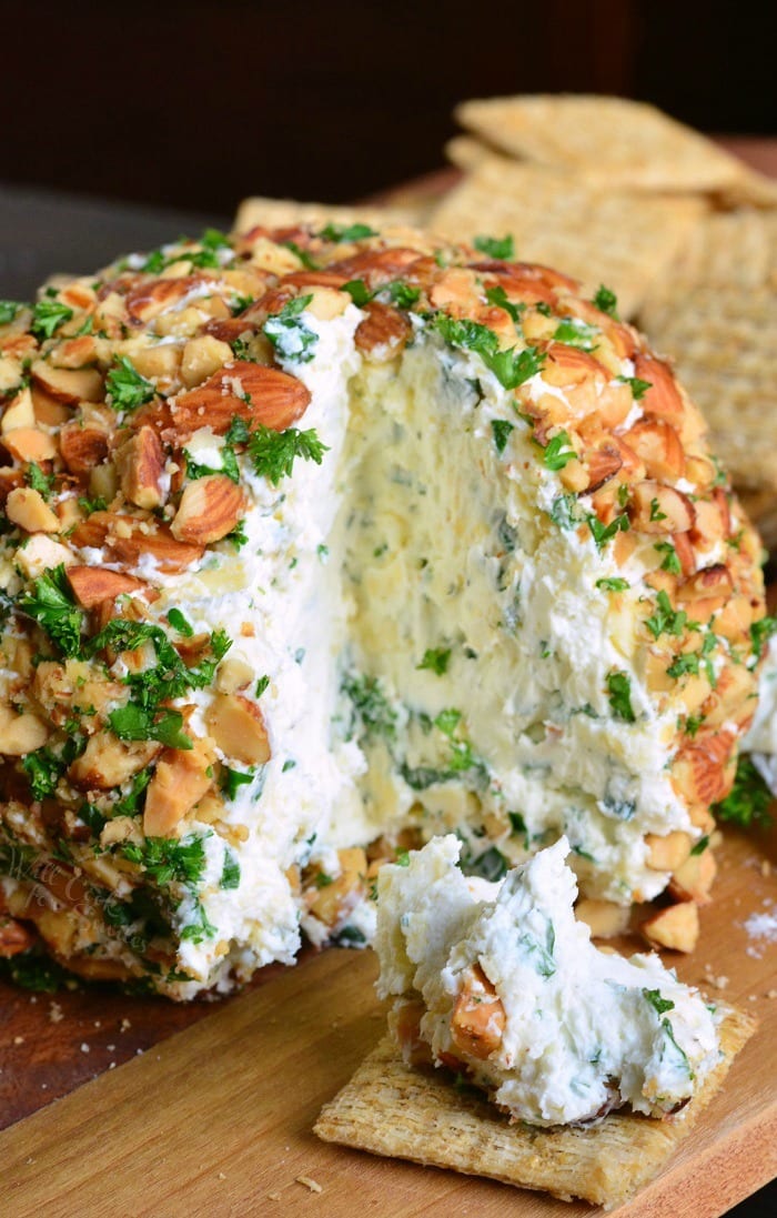 Ranch Cheddar Cheese Ball with some of it on a wheat thin on a cutting board 