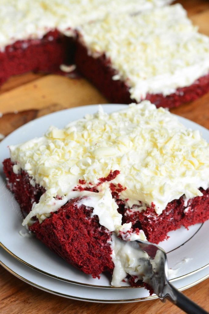 Red Velvet Brownies on a plate with a fork on a wood cutting board 