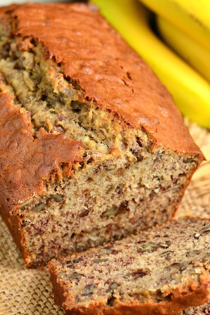 Banana Bread with a slice cut off on a burlap table cloth 