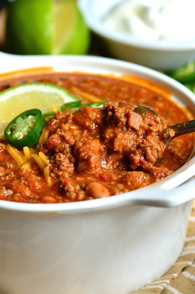 scooping out some chili from a bowl with a spoon.