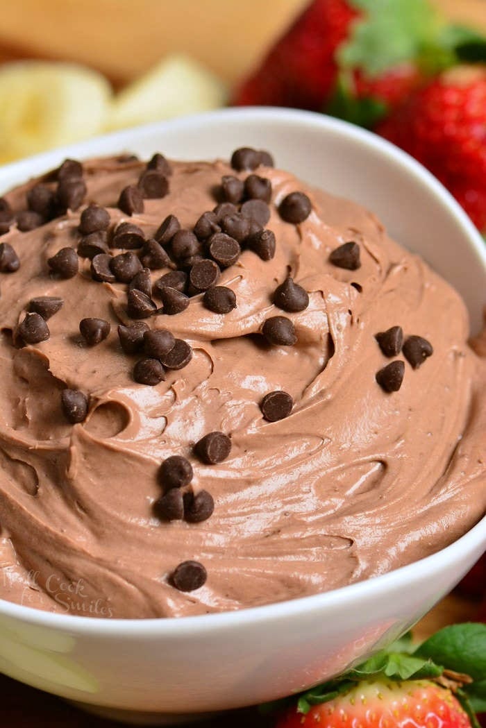 chocolate cake fruit dip in a white bowl with strawberries around it.