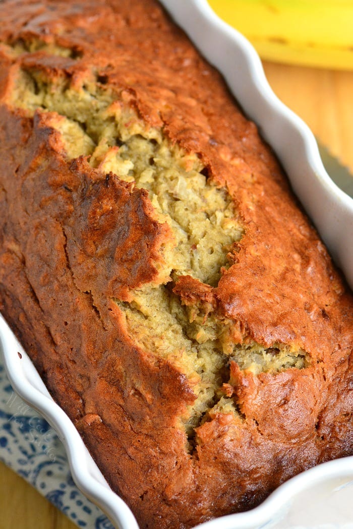 Coconut Banana Bread in a loaf pan on a cutting board 