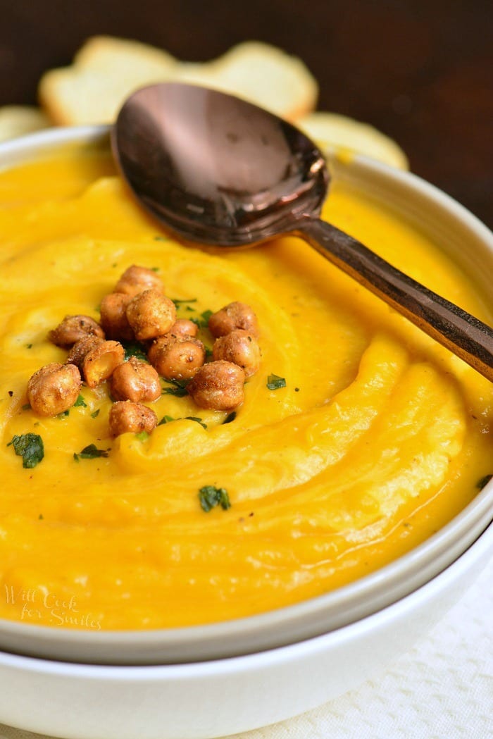 Butternut Squash Soup in a bowl with chick peas on top and a spoon 