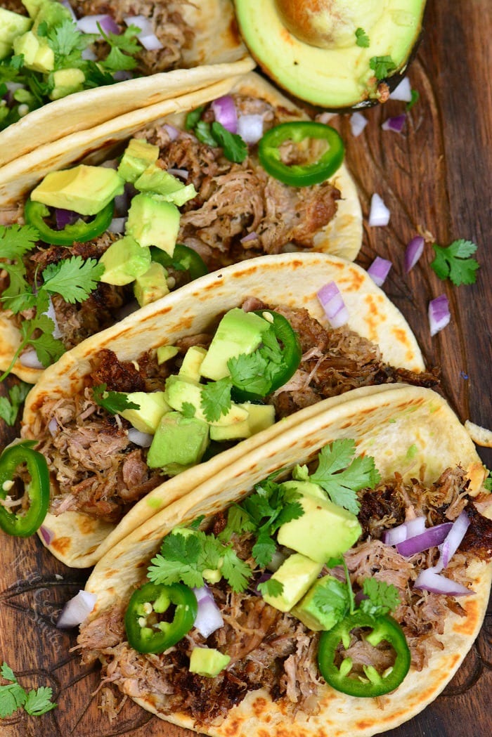 Carnitas with toppings on a cutting board 