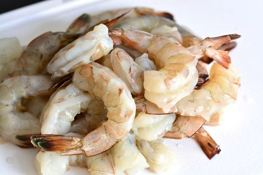 uncooked peeled and deveined shrimp in a mount in a cutting board. 