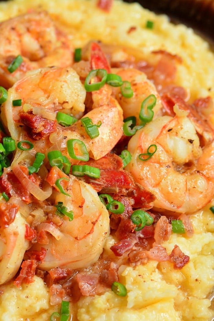 Shrimp and Grits is a wonderful southern classic that consists of buttery, cheesy grits topped with juicy shrimp that's been cooked with bacon and sub dried tomatoes. #shrimp #dinner #easydinner #grits