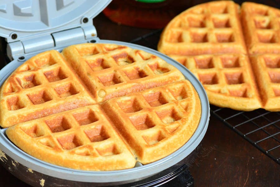 waffle in a waffle iron and a waffle on the side plate.