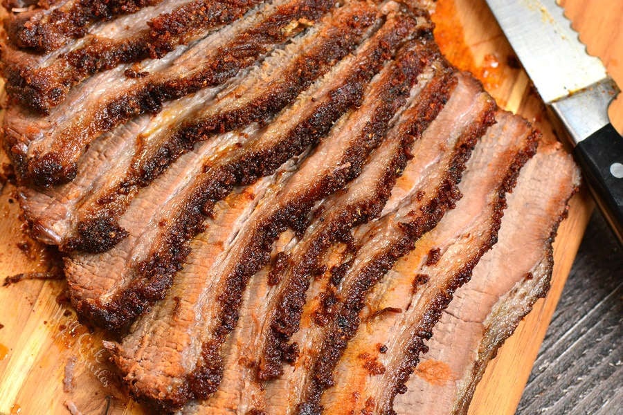 Beef Brisket cut up on wood cutting board  with knife